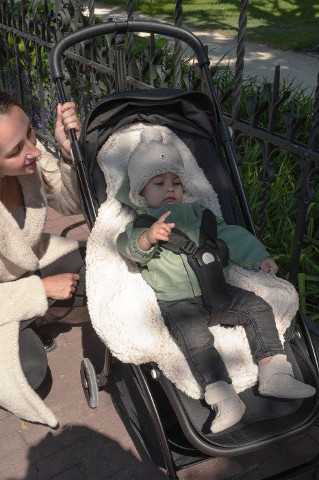 Lodger Bunker Folklore Fleece vissezonas guļammaiss beige krāsa, bildē redzams mazulis ar guļammaisa iekšas materiālu ratiņos.