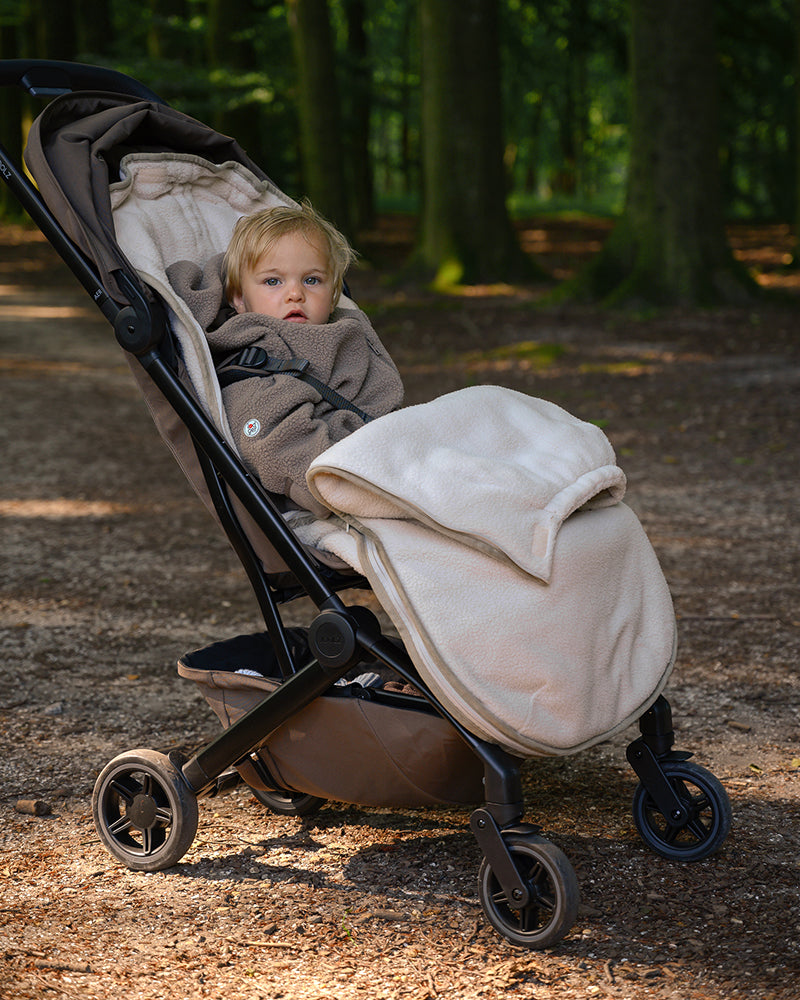 Lodger Mini Bunker Teddy vissezonas guļammaiss birch krāsa, bildē mazulis guļammaisā un ratiņos.