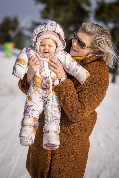 Lodger Skier Empire kombinezons, Lotus, SK 500, redzama priekša, bildē mazulis tiek turēts rokās ar kombinezonu.