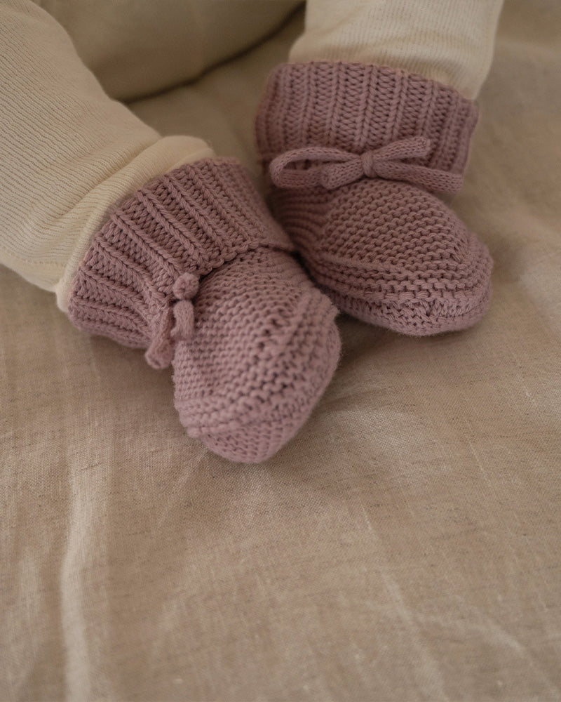Lodger Slipper knit kokvilnas čībiņas rose krāsā. Redzamas no priekšpuses uzvilktas uz mazuļa pēdiņām.
