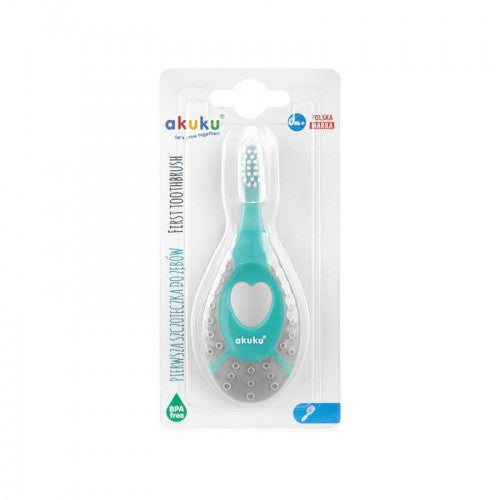 Akuku pirmā zobu birstīte mazuļiem. Zaļā un pelēkā krāsā, redzama no priekšpuses iepakojumā.