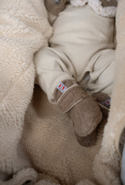 Lodger slipper fleece čībiņas buffalo krāsā redzama uzvilkta uz mazuliša kājiņas