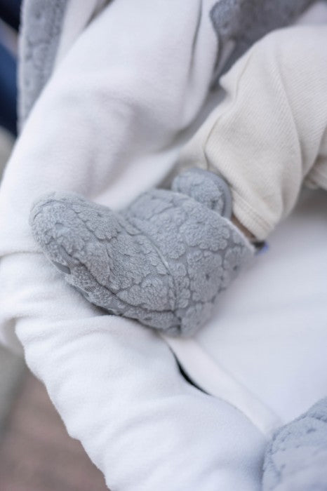 Lodger slipper flīsa čībiņas pelēkā krāsā, redzama uzvilkta uz mazuļa kājiņas