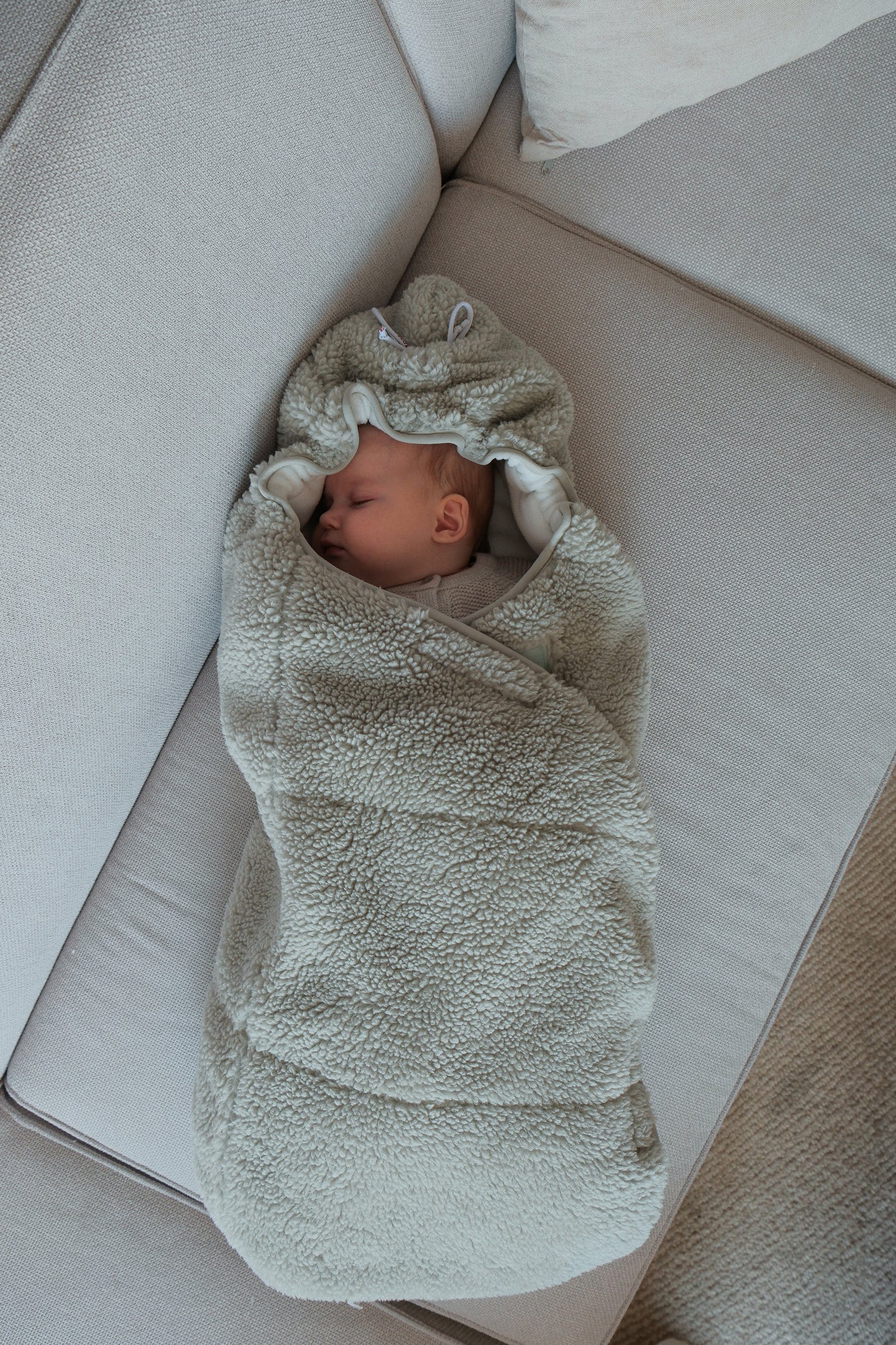 Lodger Wrapper Teddy ietinamā sedziņa silk krāsā. Redzams guļošs mazulītis ietīts sedziņā