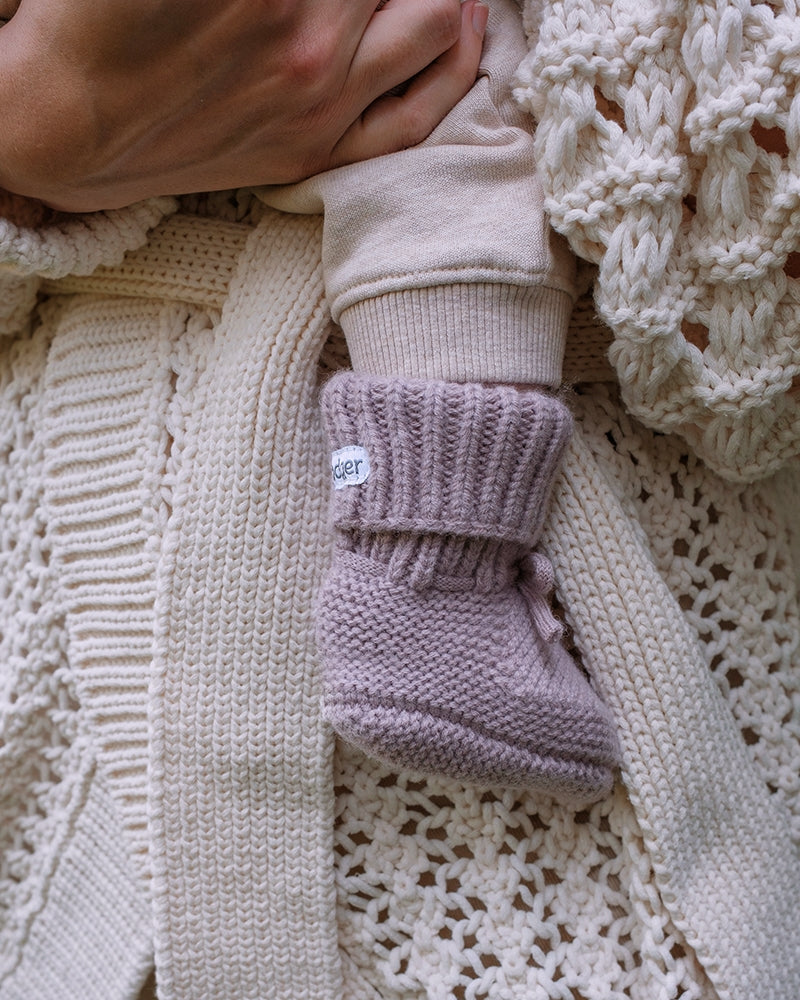 Lodger Slipper Merino vilnas čībiņas rose krāsā. Redzamas uzvilktas mazuļa kājiņā.