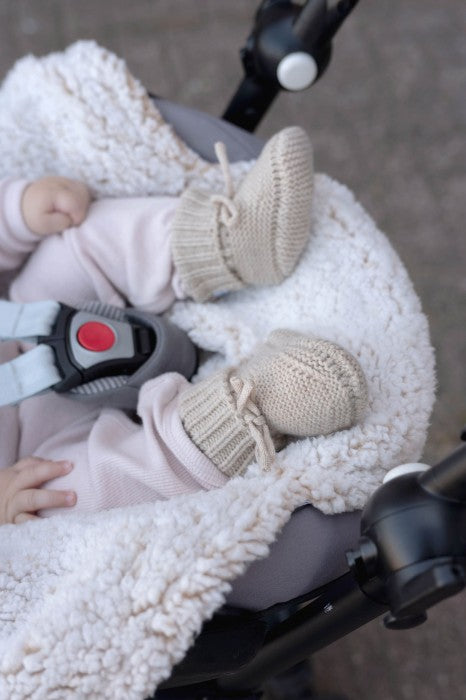 Lodger Slipper Merino vilnas čībiņas birch krāsā. Redzamas no priekšpuses un sāna uzvilktas uz mazuļa kājiņām.