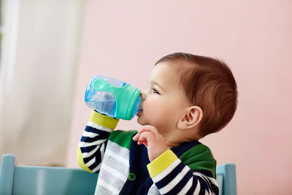 Philips Avent Easy Sip mācību krūzīte ar rokturiem, zilā krāsā. Attēlā redzams bērns, kas dzer no krūzītes.